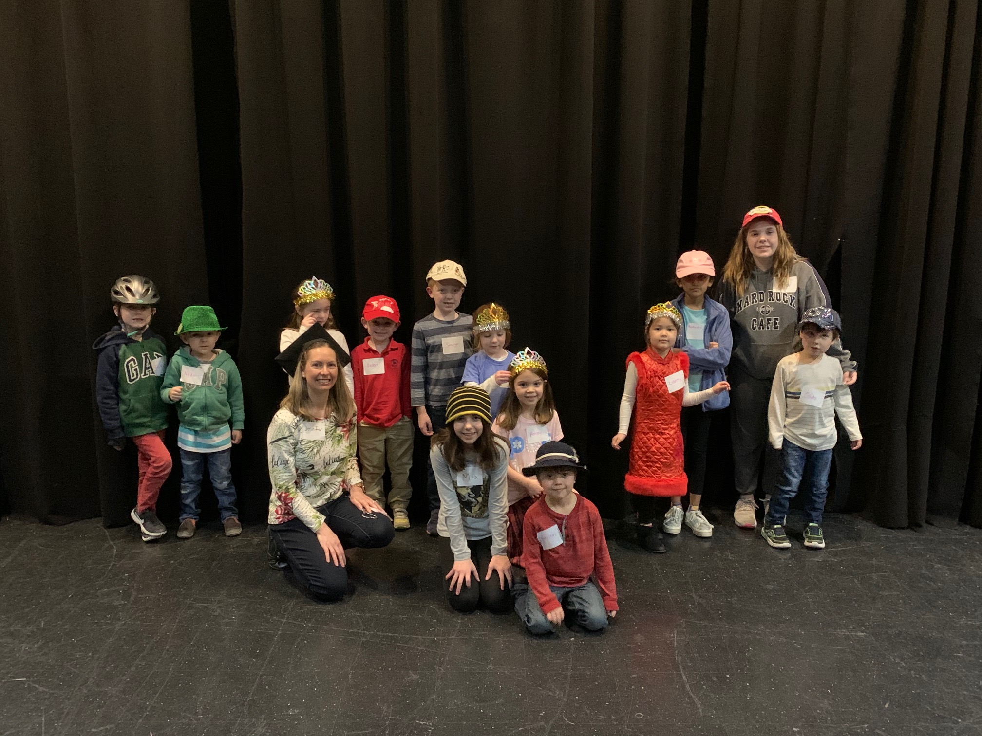 Young students pose in hats before their class showcase