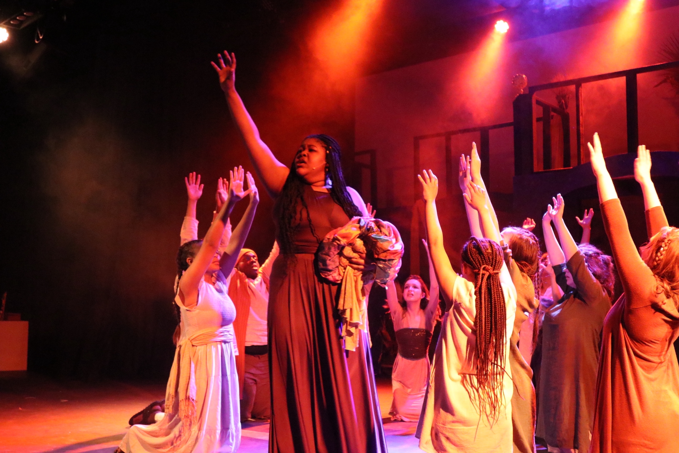 Teen actors reach towards the sky in performance of Aida