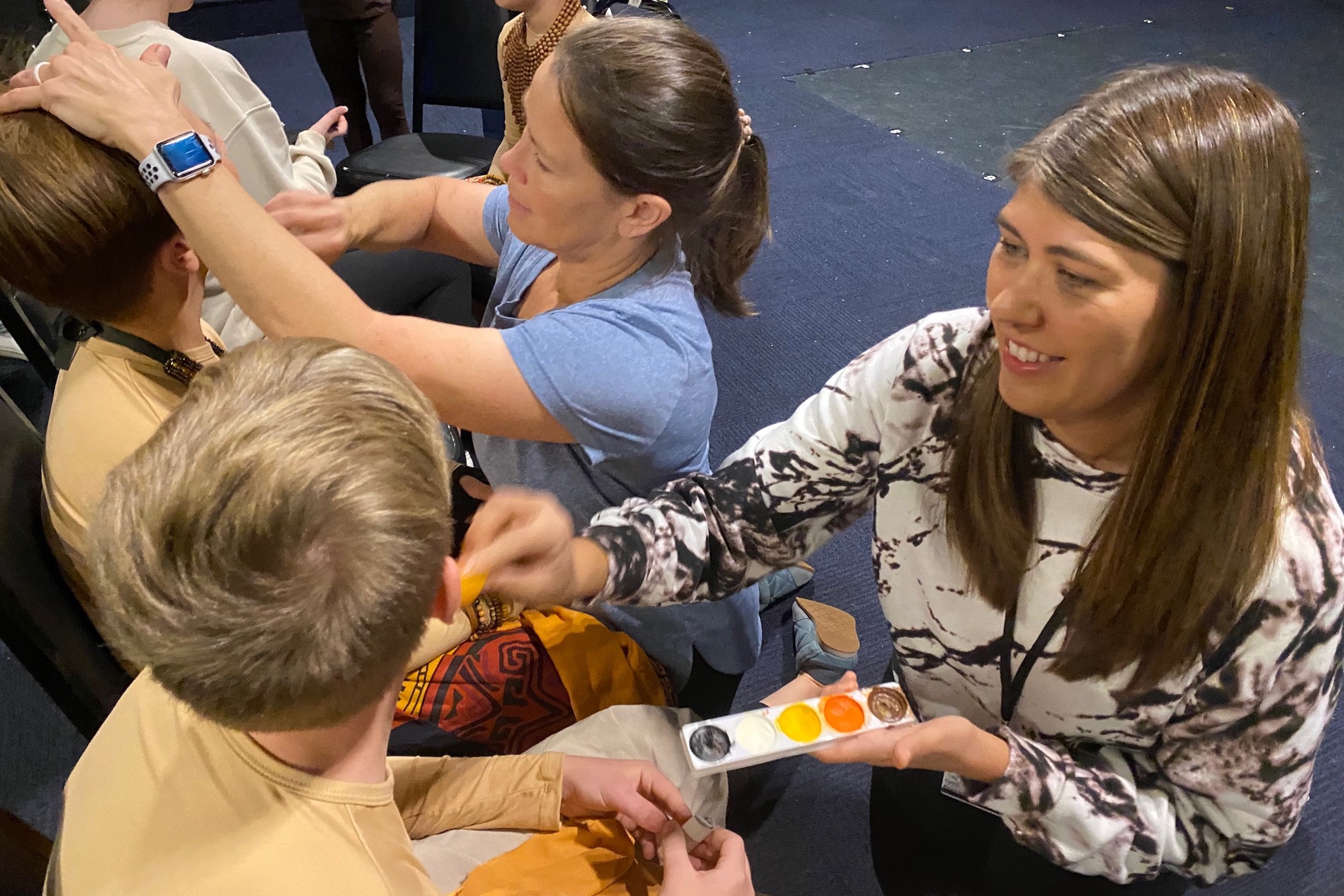 Volunteers paint faces of child actors