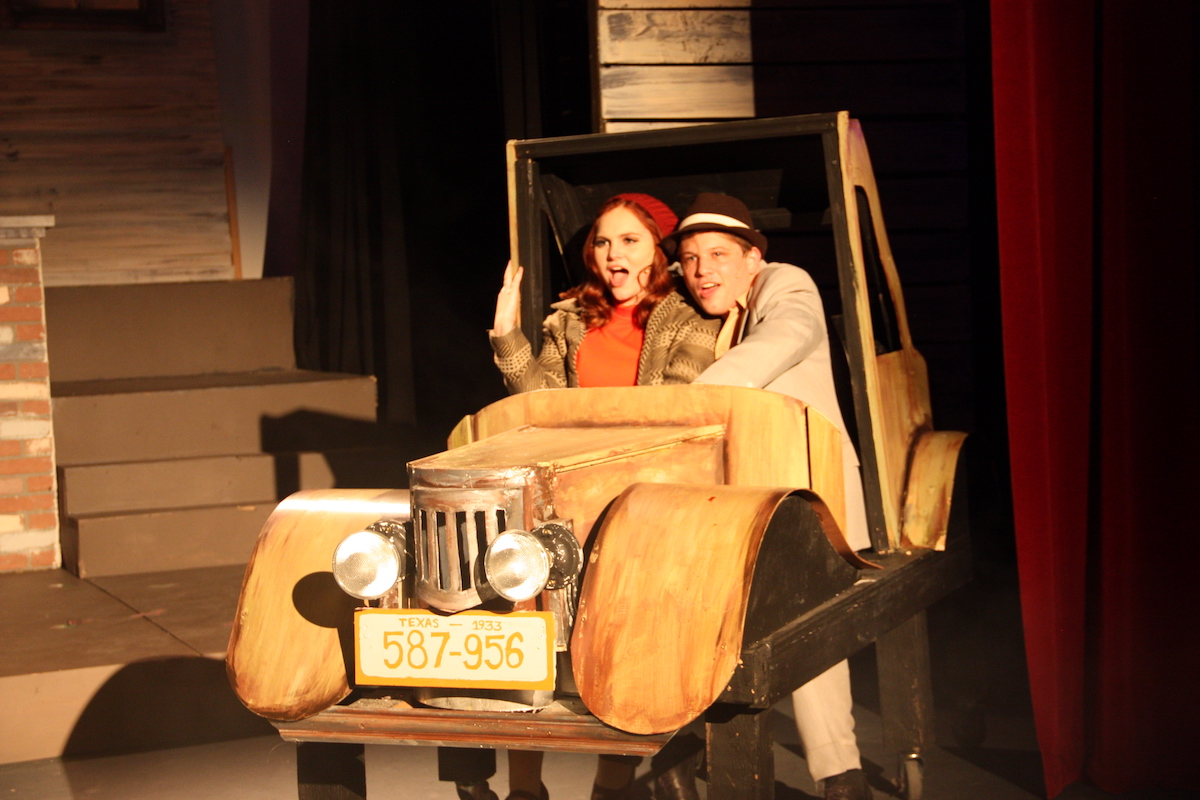 2024 Academy girl and boy sit in a car performing in Bonnie and Clyde